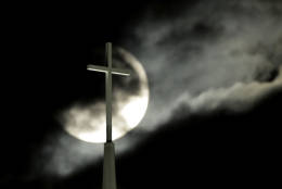 Partially obscured by clouds, a full moon rises behind the cross atop Lenexa Baptist Church, Monday, Nov. 14, 2016, in Lenexa, Kan. November's full moon is the brightest since 1948, according to NASA. (AP Photo/Charlie Riedel)