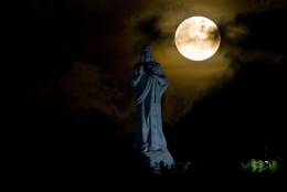 Partially obscured by clouds, a full moon rises behind the monument of Christ of Havana in Havana, Cuba, Monday, Nov. 14, 2016. November's full moon is the brightest since 1948, according to NASA. (AP Photo/Ramon Espinosa)