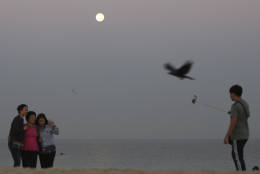 Korean tourists pose for a photo as they come to watch the supermoon at the Jumeirah beach in Dubai, United Arab Emirates, Tuesday, Nov. 15, 2016. (AP Photo/Kamran Jebreili)