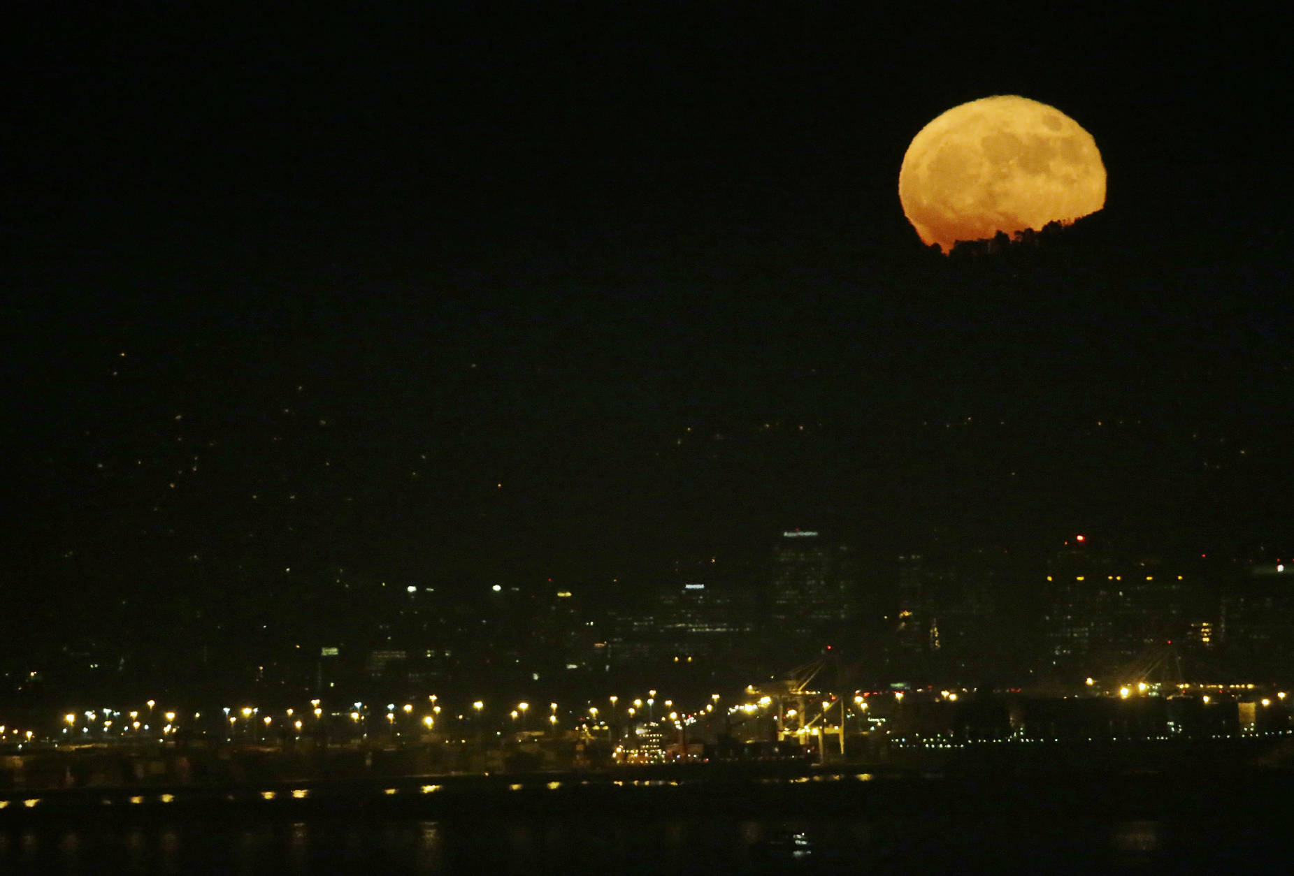 The supermoon rises over the bay area as seen from San Francisco, Monday, Nov. 14, 2016. The brightest moon in almost 69 years is lighting up the sky in a treat for star watchers around the globe. The phenomenon known as the supermoon reached its peak luminescence in North America before dawn on Monday. Its zenith in Asia and the South Pacific was Monday night. (AP Photo/Jeff Chiu)