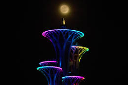 The phenomenon known as the supermoon rises over the Beijing Olympic Towers in the Olympic Green district Beijing, China, Tuesday, Nov. 15, 2016, which occurs because the moon follows an elliptical orbit around the earth. (AP Photo/Ng Han Guan)