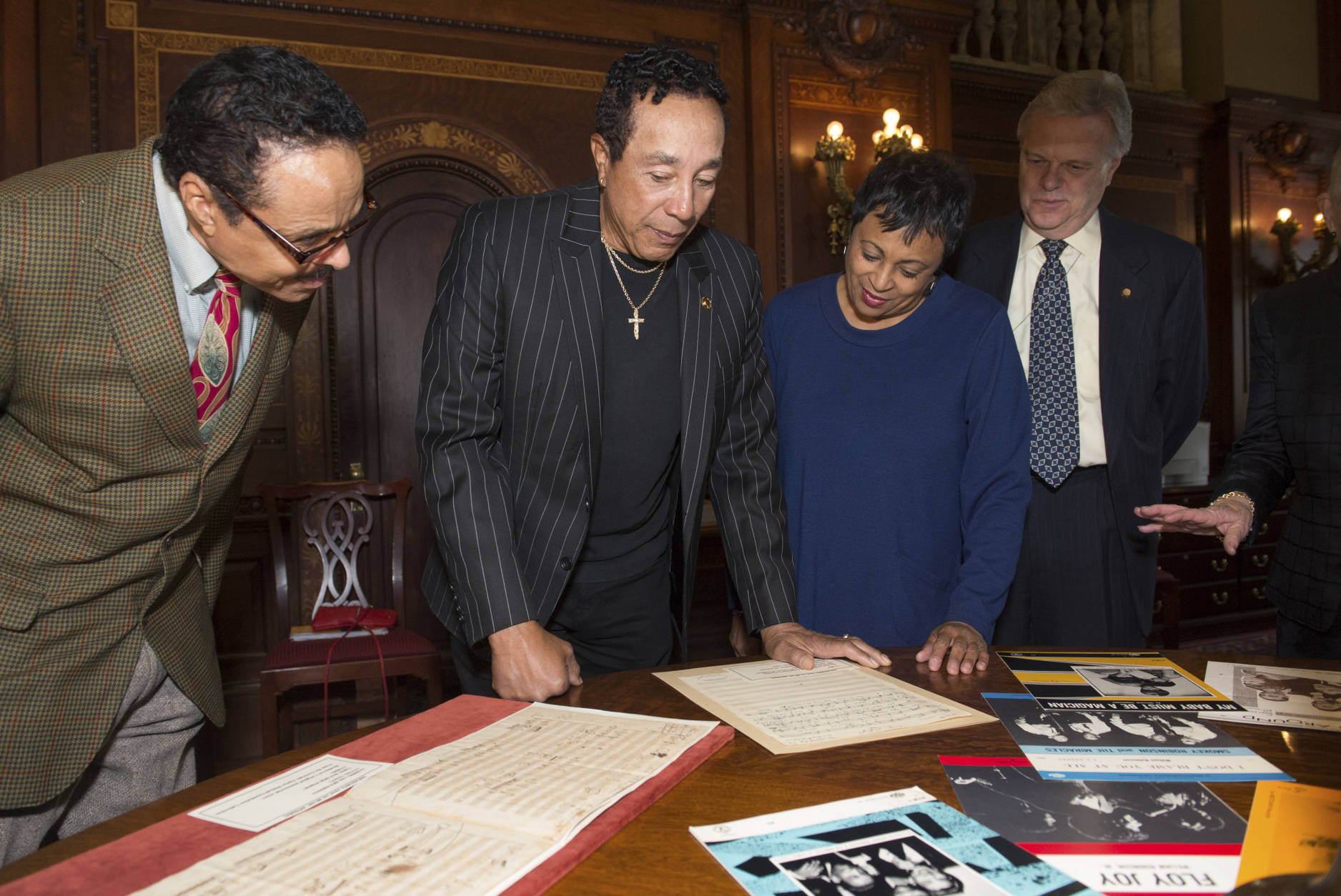 Gershwin Prize recipient Smokey Robinson looks at items from Motown era in a special display with Library of Congress Librarian Carla Hayden, second from right, and Senior Music Specialist Raymond White, right, while visiting the Library of Congress in Washington, Tuesday, Nov. 15, 2016. (AP Photo/Molly Riley)