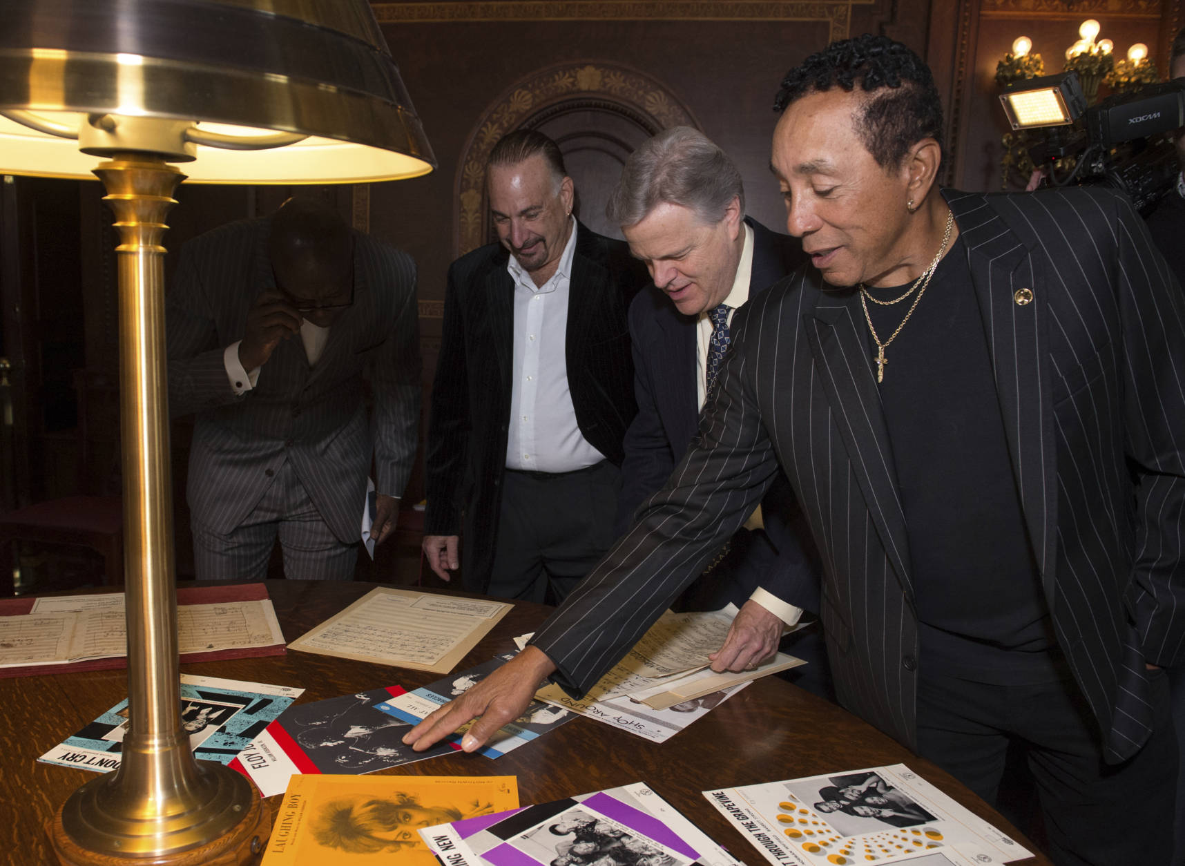 Gershwin Prize recipient Smokey Robinson looks at items in a special display with Senior Music Specialist Raymond White, center, and Robinson's music director James Demetrius Pappas, while visiting the Library of Congress in Washington, Tuesday, Nov. 15, 2016. (AP Photo/Molly Riley)