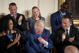 Sports broadcaster Vin Scully, center, pauses to look at his Presidential Medal of Freedom during a ceremony in the East Room of the White House, Tuesday, Nov. 22, 2016, in Washington. Obama is recognizing 21 Americans with the nation's highest civilian award, including giants of the entertainment industry, sports legends, activists and innovators. Also pictured is actor Tom Hanks, top left, singer Diana Ross, bottom left, former NBA basketball player Michael Jordan, top right, and singer songwriter Bruce Springsteen, bottom right. (AP Photo/Andrew Harnik)