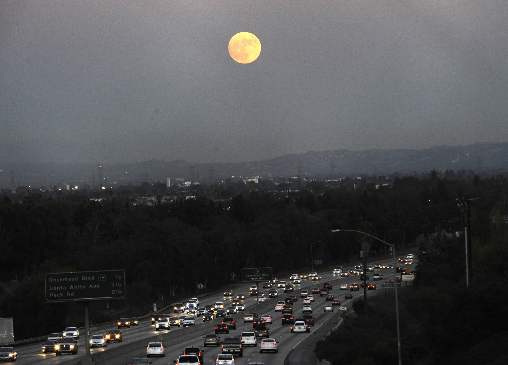 The moon rises above California 60 on Sunday, Nov. 13, 2016, in Rosemead, Calif. Monday morning's supermoon will be the closet a full moon has been to the Earth since Jan. 26, 1948. (AP Photo/Nick Ut)