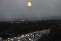 The moon rises above California 60 on Sunday, Nov. 13, 2016, in Rosemead, Calif. Monday morning's supermoon will be the closet a full moon has been to the Earth since Jan. 26, 1948. (AP Photo/Nick Ut)