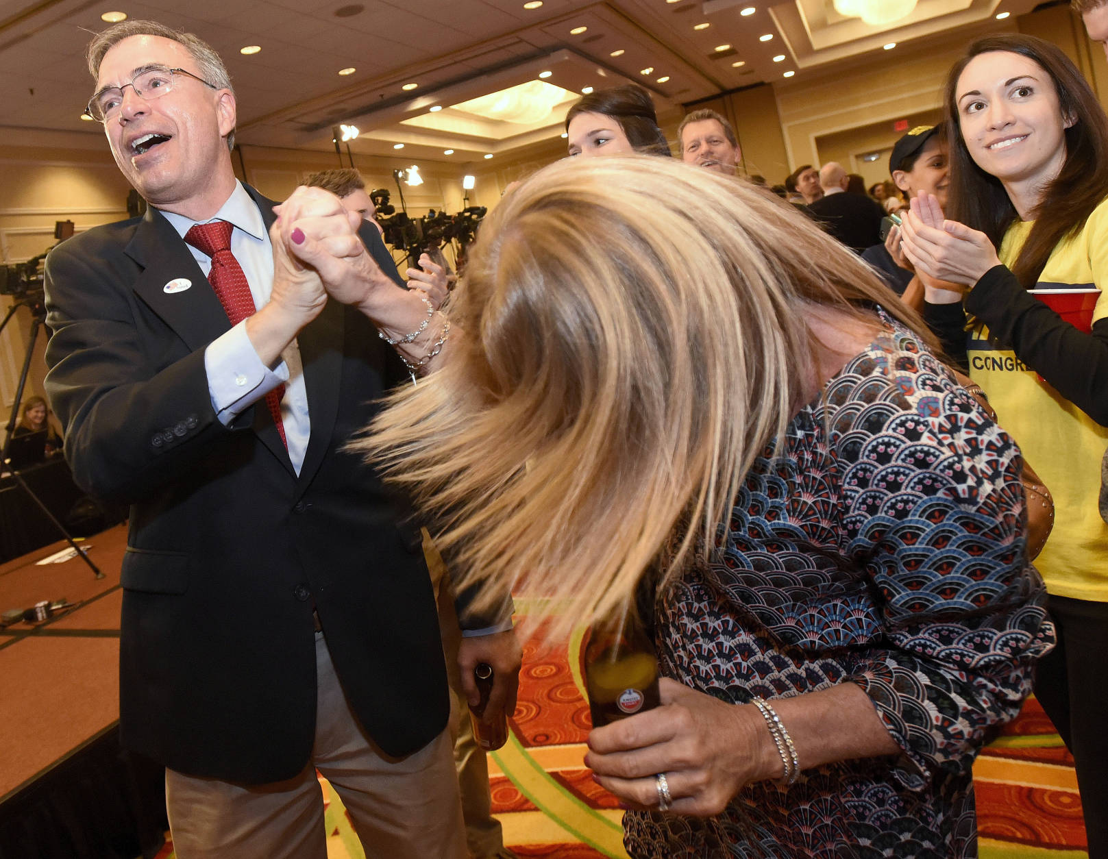 U.S. Rep. Andy Harris, left, a Maryland Republican running for re-election, high-fives supporter Debbie Peroutka, center, of Severna Park, Md., as his daughter, Rebecca Harris, right, 29, applauds during an election night party held by the Maryland Republican Party, Tuesday, Nov. 8, 2016 in Linthicum, Md. (AP Photo/Steve Ruark)