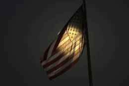 Light from the moon shines through a U.S. flag in South El Monte, Calif., Sunday, Nov. 13, 2016. Monday morning's supermoon will be the closet a full moon has been to the Earth since Jan. 26, 1948. (AP Photo/Nick Ut)