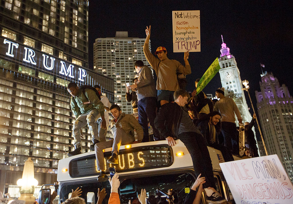 CHICAGO, IL - NOVEMBER 09: Demostrators protest on top of a bus outside of the Trump Tower November 9, 2016 in Chicago, Illinois. Thousands of people in several cities across the country took to the streets a day after Donald Trump was elected president.  (Photo by John Gress/Getty Images)