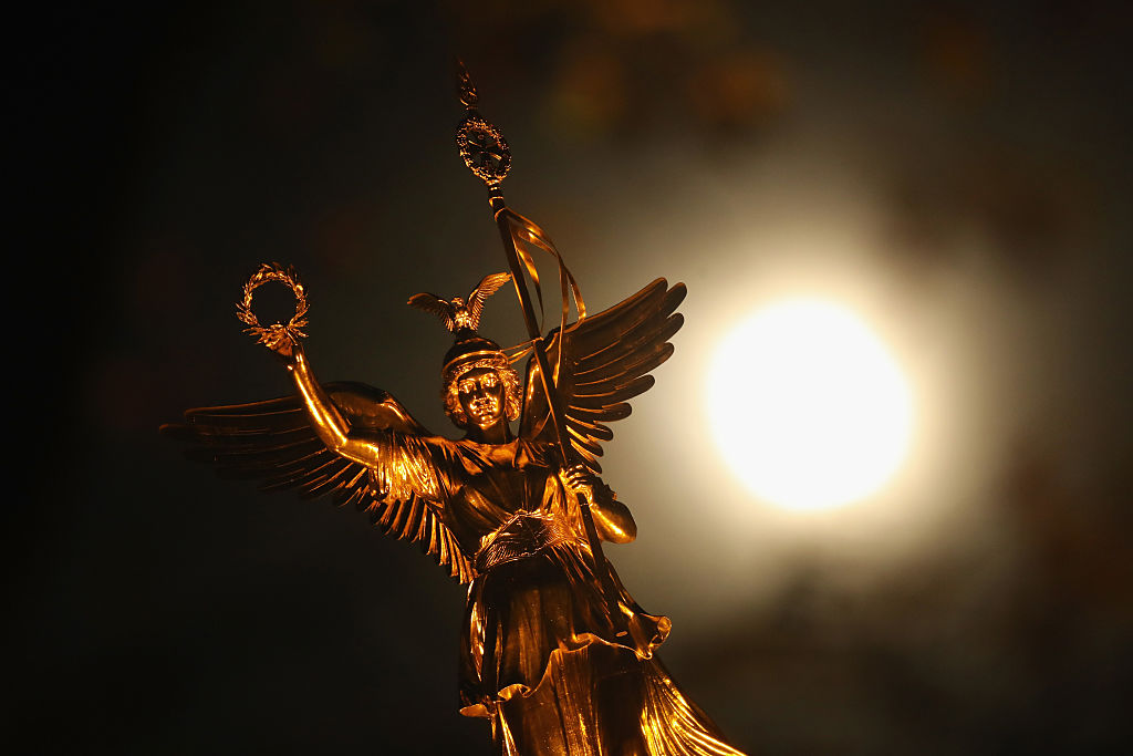 BERLIN, GERMANY - NOVEMBER 14:  The statue of Victoria stands on the Victory Column as the so-called "super moon" is visible behind on November 14, 2016 in Berlin, Germany. The "super moon" is a full moon that is at its closest in its elliptical orbit around the Earth, a confluence that last occurred 70 years ago.  (Photo by Sean Gallup/Getty Images)