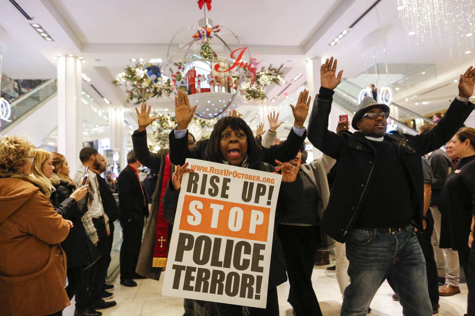 NEW YORK, NY - NOVEMBER 25:  Protesters hold up their hands as they demonstrate against racial injustice and police brutality during Black Friday events at Macy's retail store on November 25, 2016 in New York City.  In cities across the nation, protests are planned to disrupt Black Friday shopping. (Photo by Eduardo Munoz Alvarez/Getty Images)