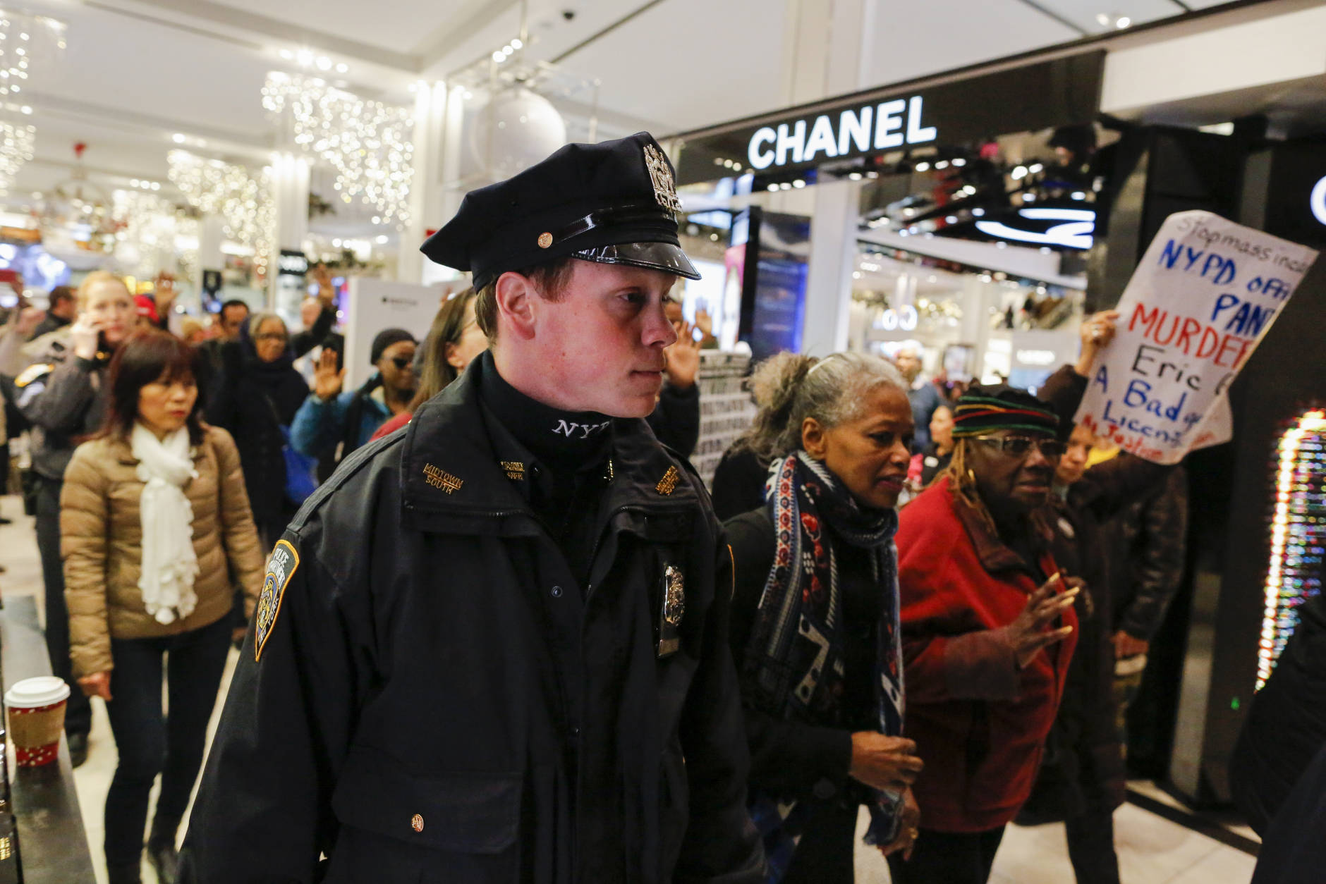 NEW YORK, NY - NOVEMBER 25:  NYPD officer keeps an eye on protesters as they demonstrate against racial injustice and police brutality during Black Friday events at Macy's retail store on November 25, 2016 in New York City.  In cities across the nation, protests are planned to disrupt Black Friday shopping. (Photo by Eduardo Munoz Alvarez/Getty Images)
