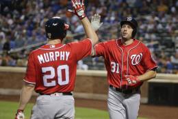Washington Nationals' Max Scherzer (31) is greeted by Daniel Murphy (20) after scoring on a triple by Ben Revere during the third inning of a baseball game, Saturday, July 9, 2016, in New York. (AP Photo/Julie Jacobson)