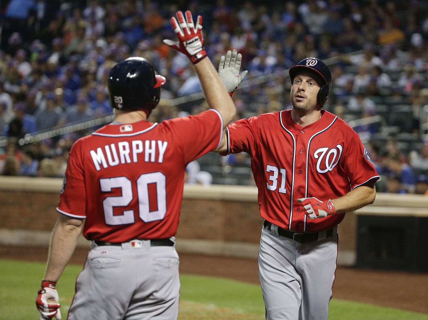 Washington Nationals' Max Scherzer (31) is greeted by Daniel Murphy (20) after scoring on a triple by Ben Revere during the third inning of a baseball game, Saturday, July 9, 2016, in New York. (AP Photo/Julie Jacobson)