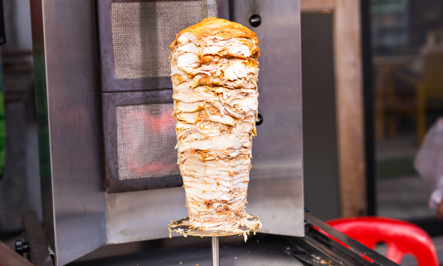 Delicious slabs of skewered fast food shawerma chicken and lamb meat turn side by side on a spit. This is common sandwich meat found in fast food in the Middle East.