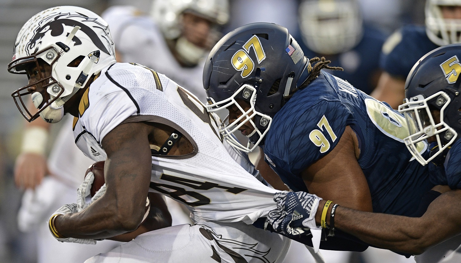 Western Michigan receiver Corey Davis, left, is grabbed by Akron defensive linemen Brennan Williams (97) and linebacker Ulysses Gilbert III in the fourth quarter of an NCAA college football game on Saturday, Oct. 15, 2016, in Akron, Ohio. (AP Photo/David Dermer)