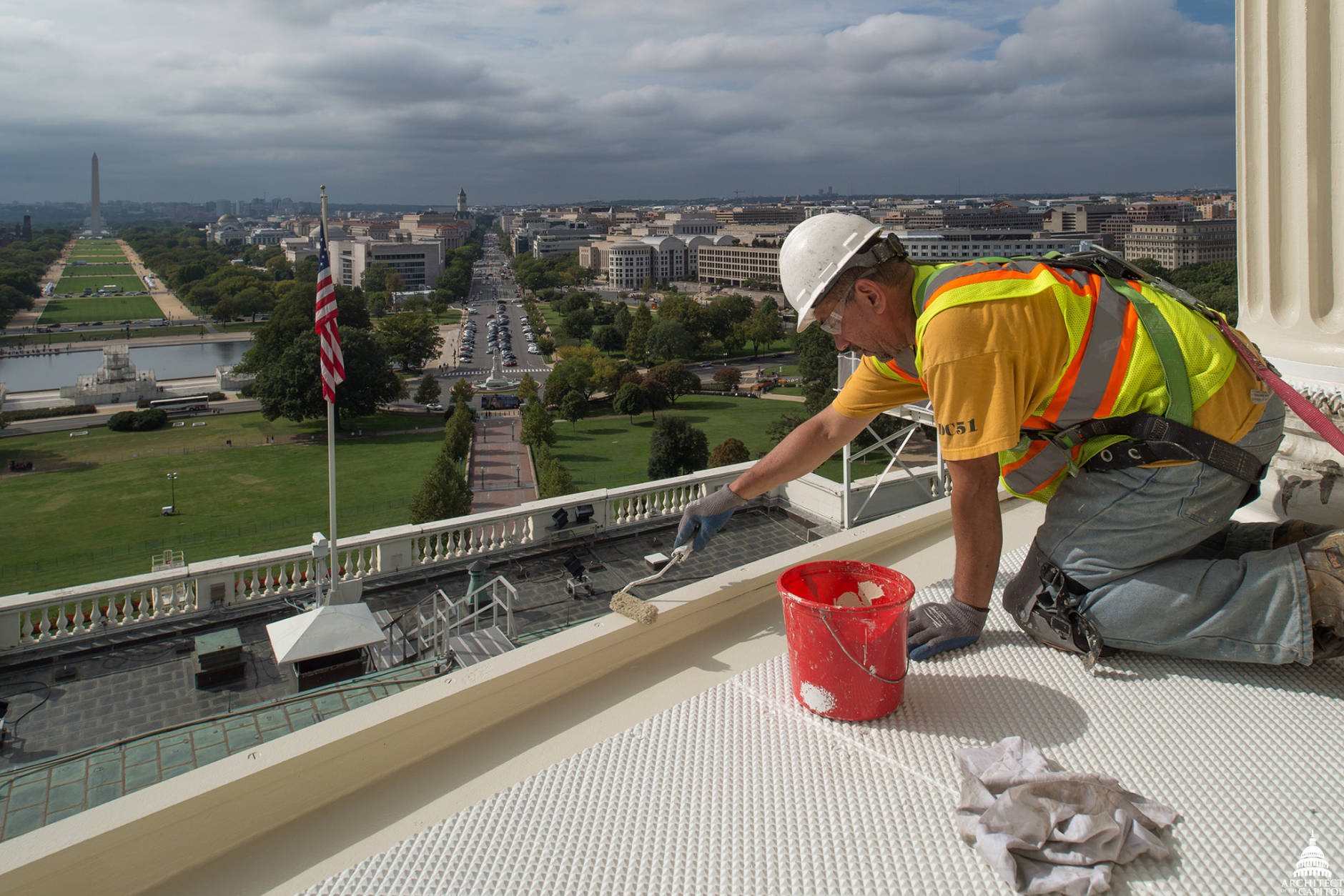 A worker paints the floor during the Capitol Dome project and has a view of the Washington Monument. (Architect of the Capitol)