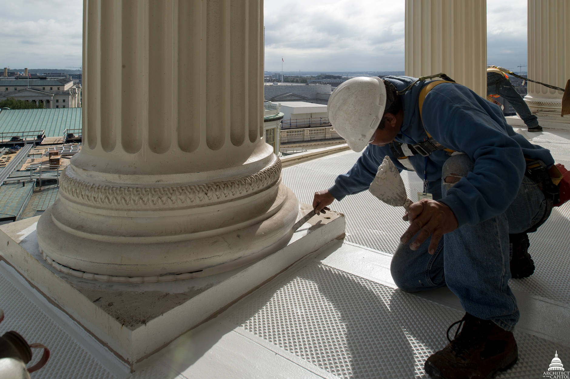 A worker paints the floor during the Capitol Dome project and has a view of the Washington Monument. (Architect of the Capitol)