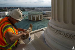 A worker paints the floor during the Capitol Dome project. (Architect of the Capitol)