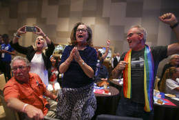 Deb Lomando, center, and Kavin Burkhalter, right, cheer as early results come in during an election watch party for Democrats, Tuesday, Nov. 8, 2016, in Las Vegas. (AP Photo/Chase Stevens)