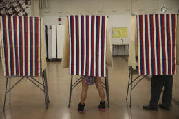 Voters cast their ballots in booths at Farrington High School, Tuesday, Nov. 8, 2016, in Honolulu. (AP Photo/Marco Garcia)