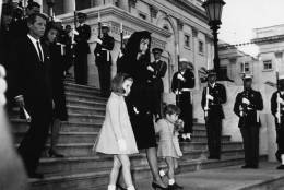 Jackie Kennedy (1929 - 1994) and her children John Jr. (1960 - 1999) and Caroline, walking down steps past a guard of honour at the funeral of President Kennedy. Robert Kennedy is following them. (Photo by Central Press/Getty Images)