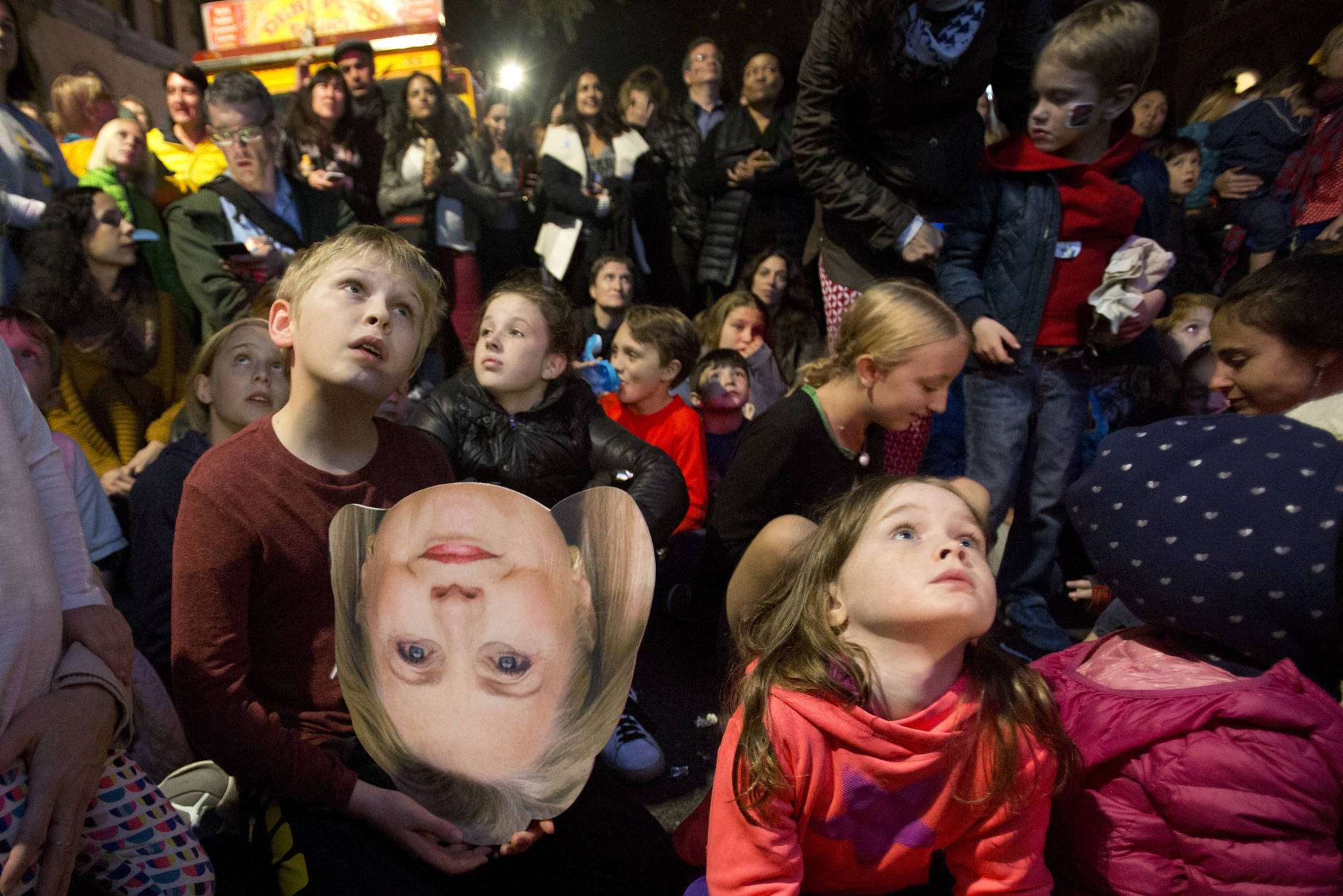 A boy holds a photo of Democratic presidential candidate Hillary Clinton during an election night block party in the Carroll Gardens neighborhood, Tuesday, Nov. 8, 2016, in the in the Brooklyn borough of New York. (AP Photo/Mark Lennihan)