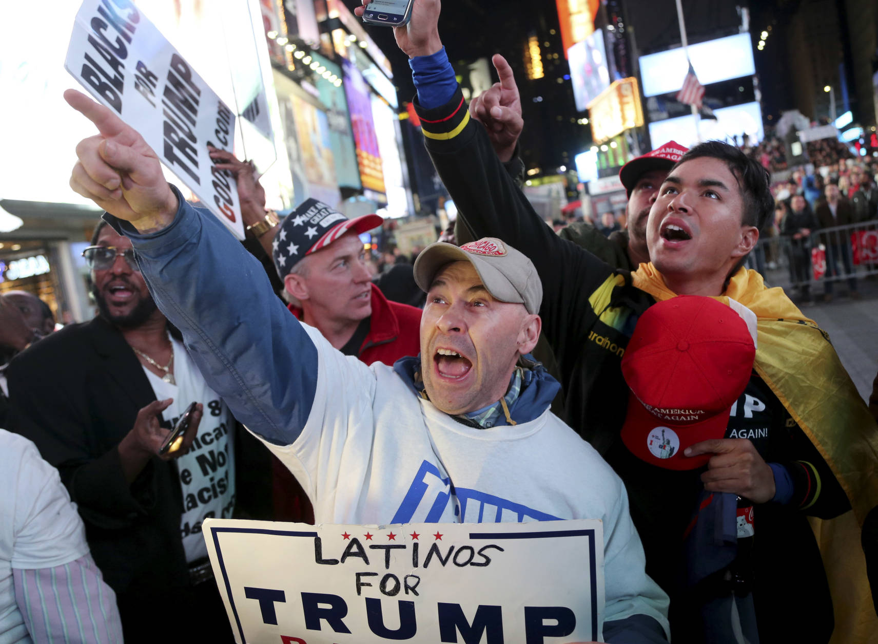 Supporters of Republican presidential candidate Donald Trump react to reports that he had won North Carolina while they were watching results in Times Square, New York, Tuesday, Nov. 8, 2016. (AP Photo/Seth Wenig)