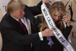 Donald Trump place a sash on Miss California USA, Carrie Prejean following a news conference in New York, Tuesday May 12, 2009.  Trump, who owns the Miss USA pageant, says Prejean can retain her Miss California USA crown after she caused a stir expressing opposition to gay marriage and posing in risque photographs.  (AP Photo/Bebeto Matthews)