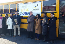 Volunteers and Prince George's County Public Schools CEO Kevin Maxwell loaded up a school bus with new coats for more than 300 homeless students. The coats were donated by the Shops at Iverson. (WTOP/Kathy Stewart)