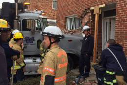 Prince George's County Fire Department crews assess the damage after a dump truck plowed into an Oxon Hill town house Wednesday morning. (Prince Geoge's County Fire Department)