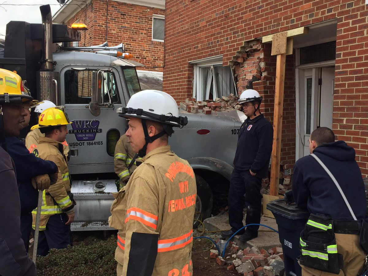 Prince George's County Fire Department crews assess the damage after a dump truck plowed into an Oxon Hill town house Wednesday morning. (Prince Geoge's County Fire Department)