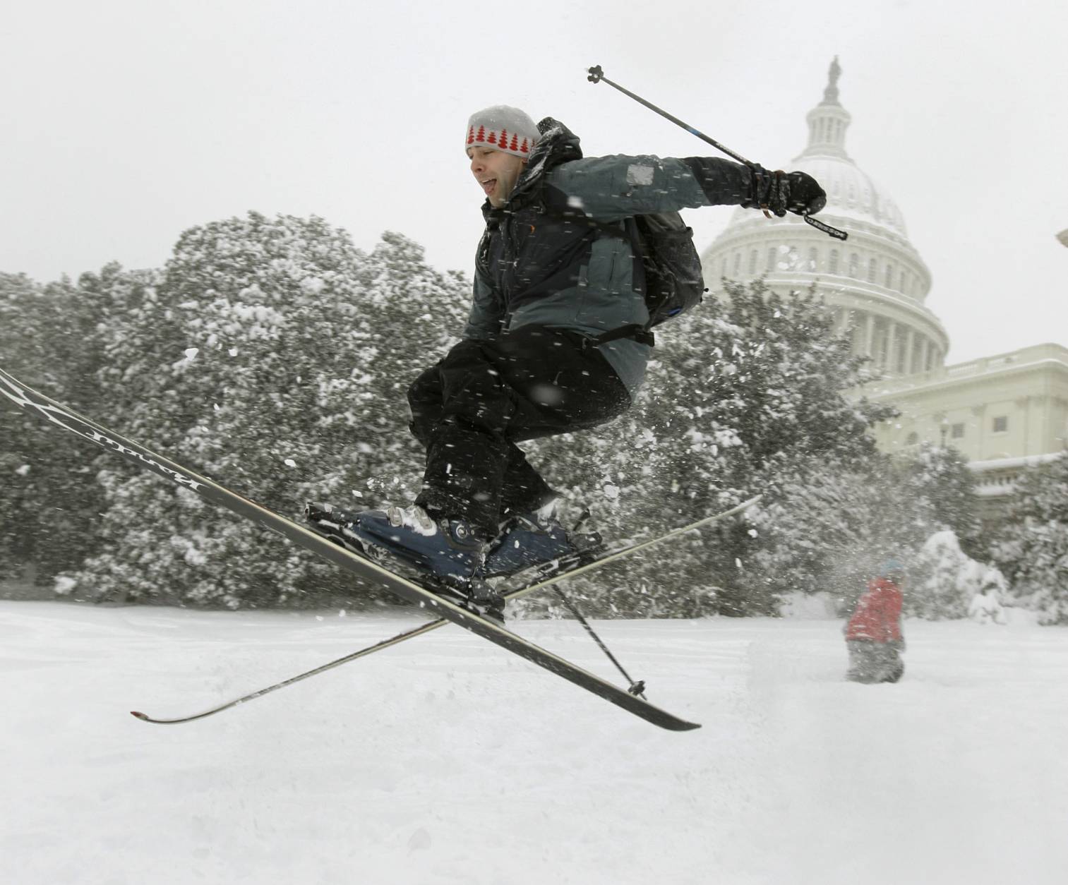 Andrew Kermick, who works on Capitol Hill, goes airborne as he skis in the snow on the West Front of the U.S. Capitol in Washington, Saturday, Dec. 19, 2009. (AP Photo/Alex Brandon)