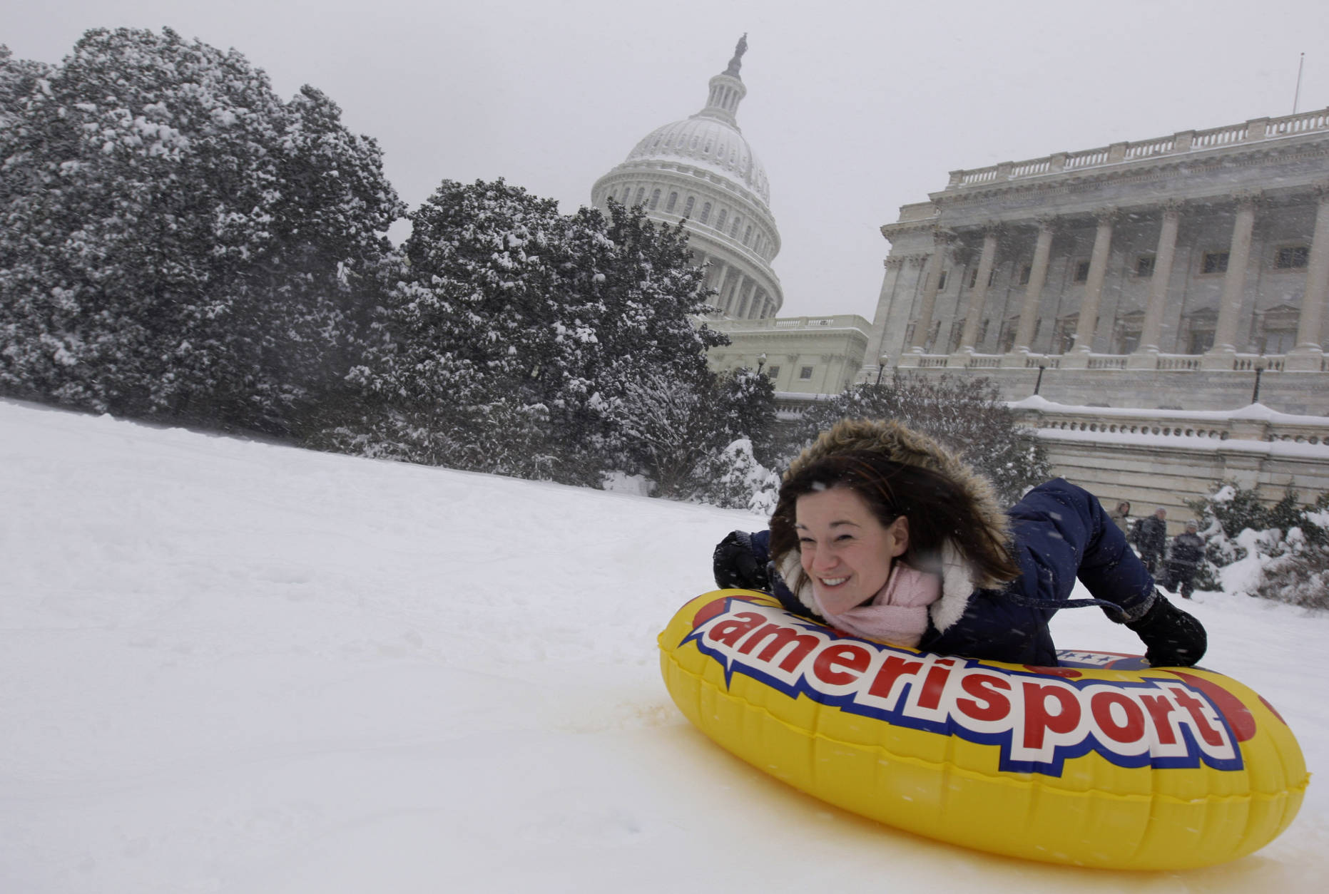Amanda Gibson uses a tube to slide down the hill in the snow on the West Front of the U.S. Capitol in Washington, Saturday, Dec. 19, 2009.(AP Photo/Alex Brandon)