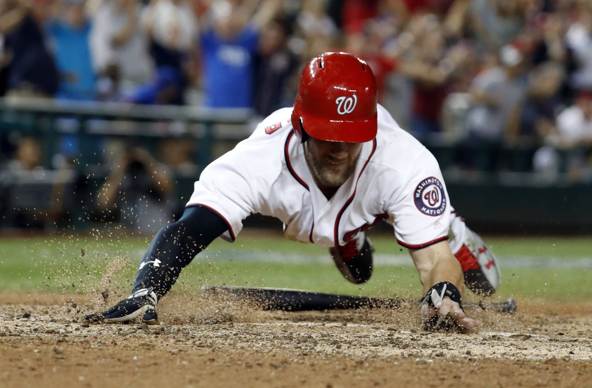 Washington Nationals' Bryce Harper dives for home scoring a run during the ninth inning of a baseball game against the New York Mets at Nationals Park, Tuesday, Sept. 13, 2016, in Washington. Mets won 4-3 in 10 innings. (AP Photo/Alex Brandon)