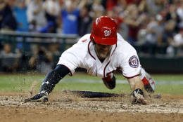 Washington Nationals' Bryce Harper dives for home scoring a run during the ninth inning of a baseball game against the New York Mets at Nationals Park, Tuesday, Sept. 13, 2016, in Washington. Mets won 4-3 in 10 innings. (AP Photo/Alex Brandon)