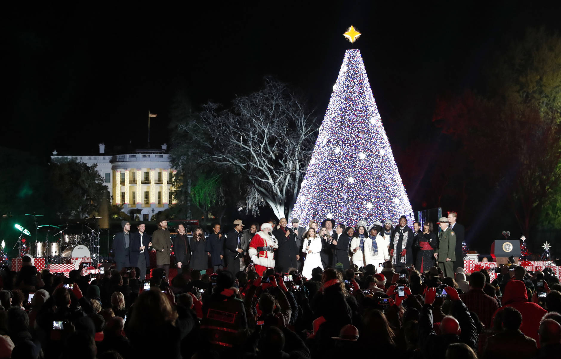Visitors use their cell phone cameras to capture the moment of the 2016 National Tree lighting. Experts warn consumers should rely only on cellular connections to prevent themselves from being hacked in large crowds. (AP Images)