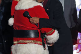 President Barack Obama, center, hugs Santa Claus, with James Taylor, right, during the lighting ceremony for the 2016 National Christmas Tree is seen before the lighting ceremony on the Ellipse near the White House, Thursday, Dec. 1, 2016 in Washington. (AP Photo/Alex Brandon)