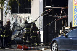 Firefighters clear an entry to a smoldering building after a fire tore through a warehouse party early Saturday, Dec. 3, 2016 in Oakland.   Oakland fire chief Teresa Deloche-Reed said many people were unaccounted for as of Saturday morning and authorities were working to verify who was in the cluttered warehouse when the fire broke out around 11:30 p.m. Friday. (AP Photo/Josh Edelson)