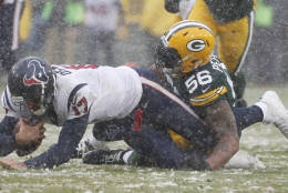 Houston Texans quarterback Brock Osweiler is sacked by Green Bay Packers' Julius Peppers during the first half of an NFL football game Sunday, Dec. 4, 2016, in Green Bay, Wis. (AP Photo/Mike Roemer)