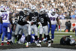 Oakland Raiders running back Latavius Murray (28) celebrates after running for a touchdown with running back Jamize Olawale (49) and offensive guard Kelechi Osemele (70) against the Buffalo Bills during the second half of an NFL football game in Oakland, Calif., Sunday, Dec. 4, 2016. (AP Photo/D. Ross Cameron)