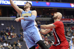 Denver Nuggets center Jusuf Nurkic, of Bosnia Herzegovina, (23) goes to the basket against Washington Wizards center Marcin Gortat, of Poland, right, during the first half of an NBA basketball game, Thursday, Dec. 8, 2016, in Washington. (AP Photo/Nick Wass)