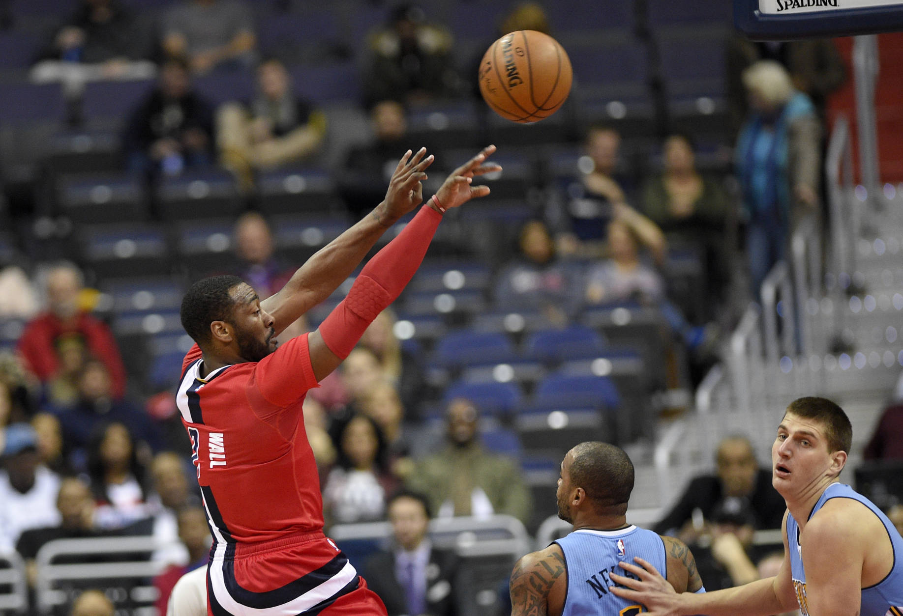 Washington Wizards guard John Wall (2) passes the ball over Denver Nuggets guard Jameer Nelson (1), bottom center, and Denver Nuggets forward Nikola Jokic, of Serbia, bottom right, during the first half of an NBA basketball game, Thursday, Dec. 8, 2016, in Washington. (AP Photo/Nick Wass)