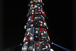 People visit Mexico City’s main plaza, the Zocalo, decked out with neon Christmas decorations and an artificial tree standing 70 meters or about 230 feet high, Sunday, Dec. 18, 2016. (AP Photo/Marco Ugarte)