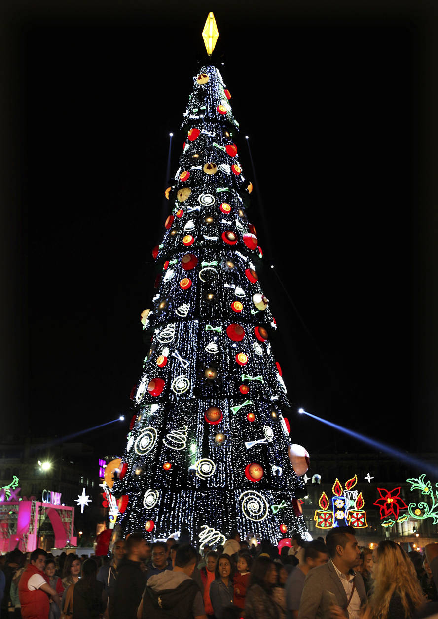 People visit Mexico City’s main plaza, the Zocalo, decked out with neon Christmas decorations and an artificial tree standing 70 meters or about 230 feet high, Sunday, Dec. 18, 2016. (AP Photo/Marco Ugarte)