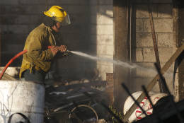A fireman sprays water at the open-air San Pablito fireworks market, in Tultepec, outskirts of Mexico City, Mexico, Tuesday, Dec. 20, 2016.  An explosion ripped through Mexico’s best-known fireworks market where most of the fireworks stalls were completely leveled. According to the Mexico state prosecutor there are at least 26 dead. (AP Photo/Eduardo Verdugo)