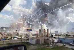 This image made from video shows an explosion ripping through the San Pablito fireworks' market in Tultepec, Mexico, Tuesday, Dec. 20, 2016. Sirens wailed and a heavy scent of gunpowder lingered in the air after the afternoon blast at the market, where most of the fireworks stalls were completely leveled. According to the Mexico state prosecutor there are at least 26 dead. (Jose Luis Tolentino via AP)