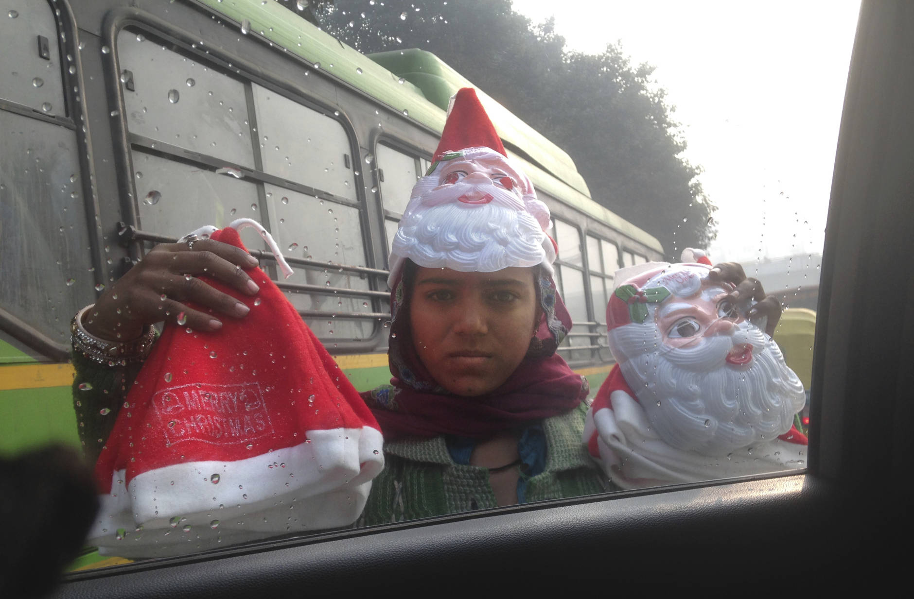 A girls sells Santa caps and masks at a traffic intersection on the Christmas eve in New Delhi, India, Saturday, Dec. 24, 2016. Though the Hindus and Muslims comprise majority of the population in India, Christmas is a national holiday celebrated with much fanfare. (AP Photo/Yirmiyan Arthur)
