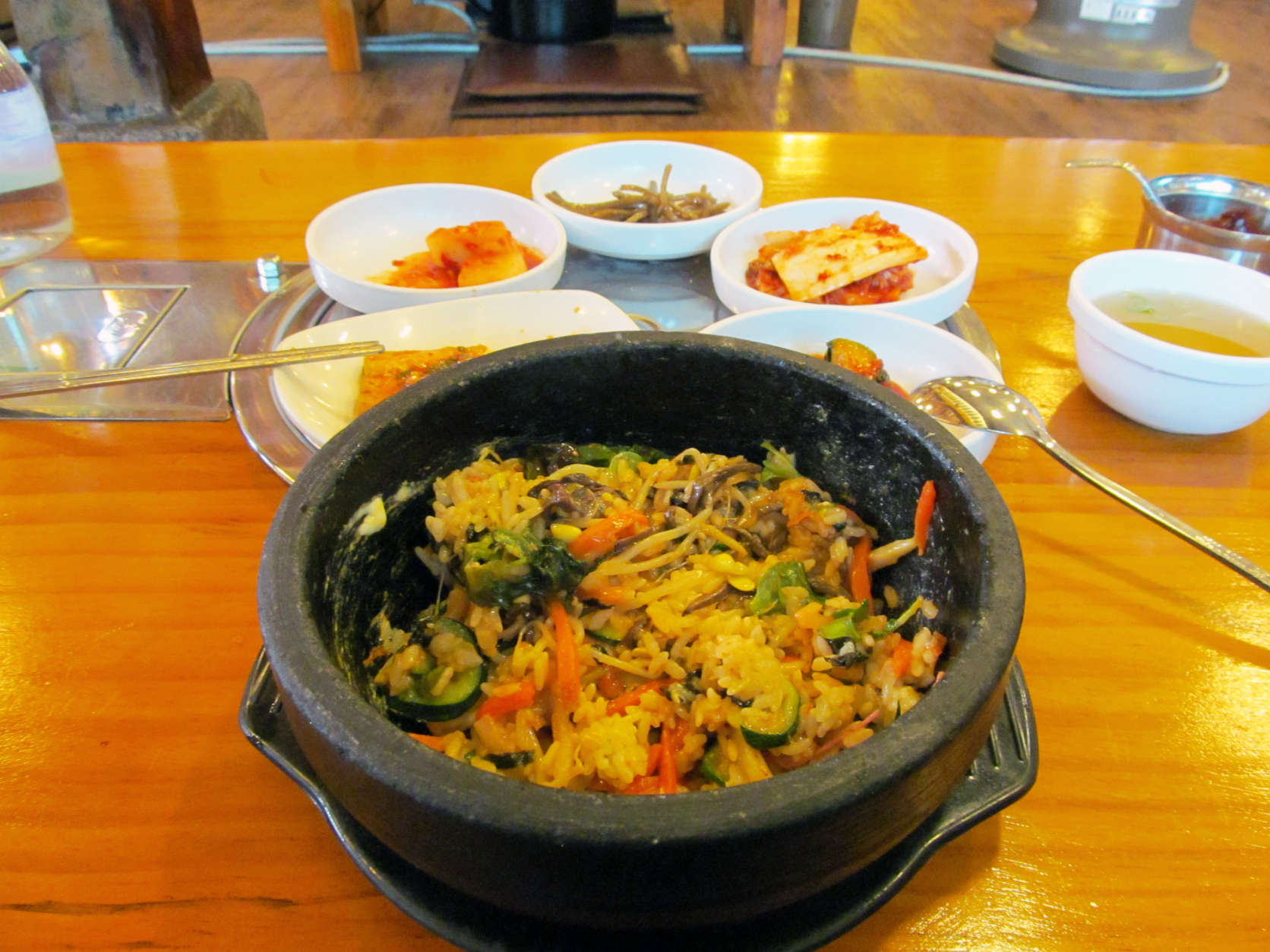 This February 2014 photo shows a traditional Korean dinner of bibimbap, a dish made of rice, sliced beef, vegetables and chilies, accompanied by several smaller plates of pickles and kimchi in Seoul, Korea. Seouls hyper-efficient capital draws visitors with its exquisite restaurants, historic palaces and ultramodern infrastructure. (AP Photo/Amir Bibawy).