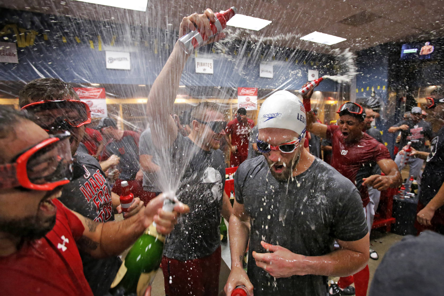 Washington Nationals' Bryce Harper, right, and Anthony Rendon, left, and Mark Melancon, center, celebrate after clinching the National League East following a  6-1 win over the Pittsburgh Pirates in a baseball game in Pittsburgh, Saturday, Sept. 24, 2016. (AP Photo/Gene J. Puskar)